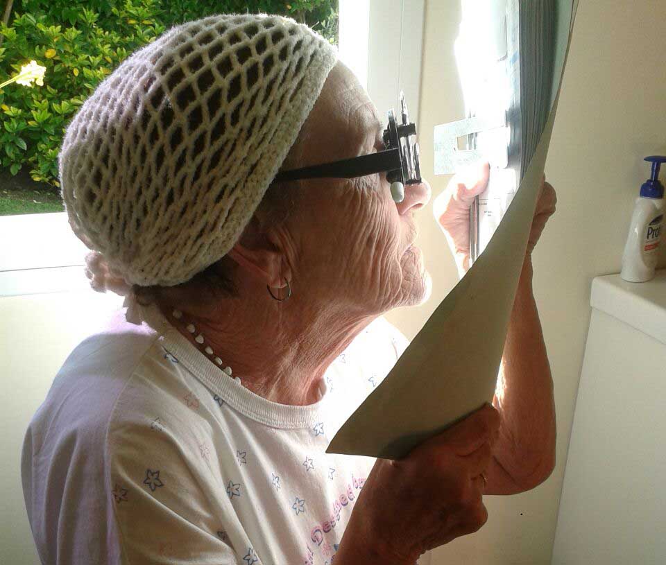 Paciente utilizando ayudas ópticas para baja visión